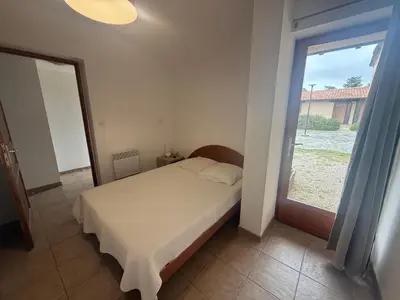 a bedroom with a bed and a large window at Mini-villa 4 personnes - Soléa 82 - vue nature in Serra-di-Ferro
