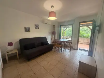 a living room with a couch and a table at Mini-villa 4 personnes - Soléa 82 - vue nature in Serra-di-Ferro