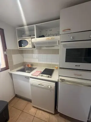 a kitchen with white cabinets and a stove top oven at Mini-villa 4 personnes - Soléa 82 - vue nature in Serra-di-Ferro