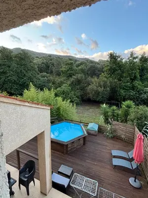 a patio with a swimming pool on a wooden deck at villa paisible à la campagne in Alata