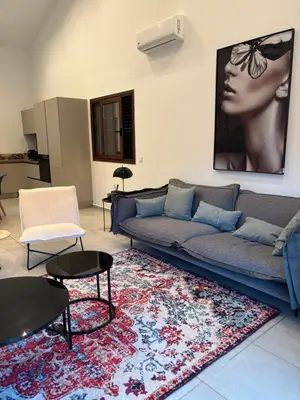 a living room with a couch and a rug at villa paisible à la campagne in Alata