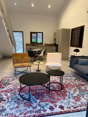 a living room with chairs and tables on a rug at villa paisible à la campagne in Alata