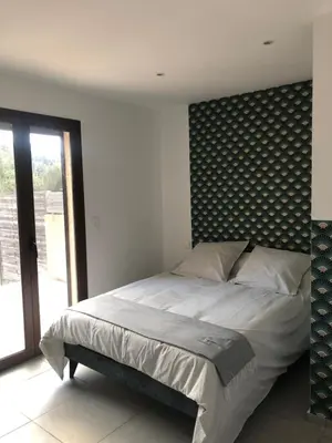 a bedroom with a large bed with a patterned headboard at villa paisible à la campagne in Alata