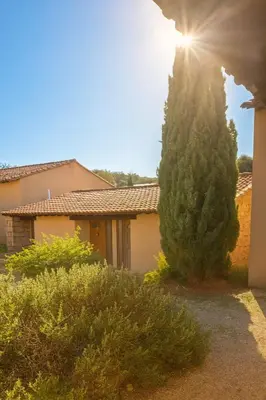 a tree in front of a house with the sun at Villa vue jardin dans résidence calme wifi piscine mer à pied in Serra-di-Ferro