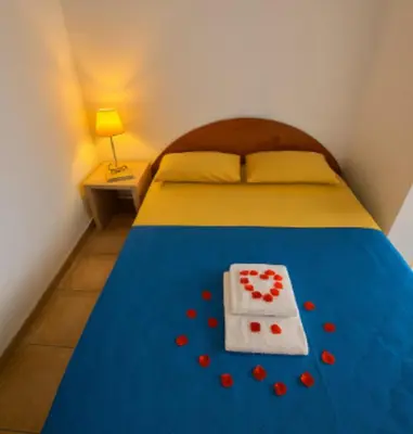 a bedroom with a bed with a heart made out of red pills at Villa vue jardin dans résidence calme wifi piscine mer à pied in Serra-di-Ferro