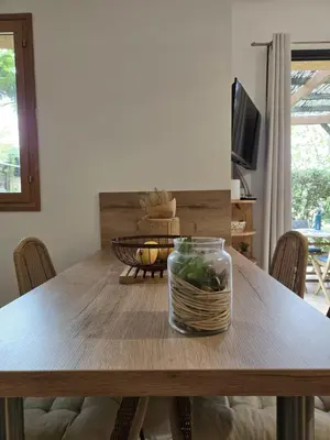 a dining room table with a jar of vegetables on it at Mini villa vue jardin dans résidence calme wifi piscine mer à pied in Serra-di-Ferro