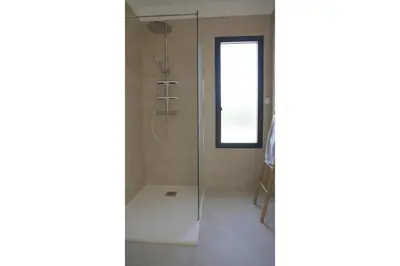 a kitchen with white appliances and a hallway at villa vue mer in Calcatoggio