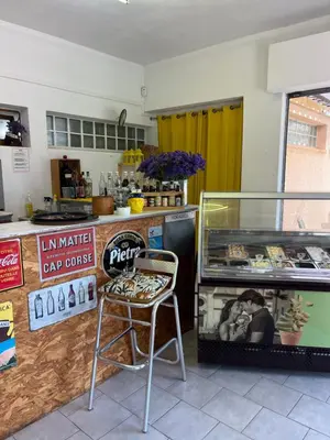 a restaurant with a chair and a counter with food at camping la vallée in Coti-Chiavari