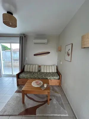 a room with a bed and a table in it at Joli appartement résidentiel plage et piscine in Poggio-Mezzana