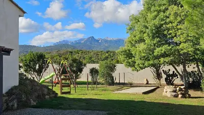 a playground with a slide in a yard with mountains at RUNDINELLE-Piscine privée- clim-wifi-plage à pieds in Solaro