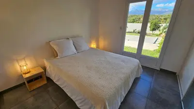 a bedroom with a bed and a large window at RUNDINELLE-Piscine privée- clim-wifi-plage à pieds in Solaro