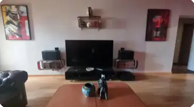 a living room with a tv and a table at F2 idéalement placé route des sanguinaires in Ajaccio