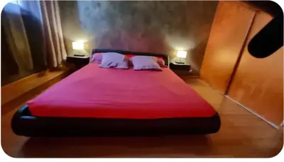 a large red bed with two pillows in a room at F2 idéalement placé route des sanguinaires in Ajaccio