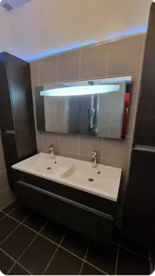 a bathroom with a white sink and a mirror at F2 idéalement placé route des sanguinaires in Ajaccio