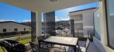 a balcony with a table and chairs and a view at Joli T2 cozy, proche plages, Terra Doru B02 in Propriano