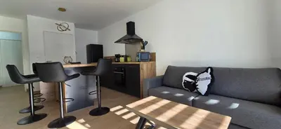a living room with a couch and a table at Joli T2 cozy, proche plages, Terra Doru B02 in Propriano
