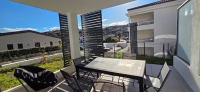 a patio with a table and chairs on a balcony at Joli T2 cozy, proche plages, Terra Doru B02 in Propriano
