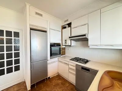 a kitchen with white cabinets and a stainless steel refrigerator at Studio K4 santa lina sanguinaires Ajaccio in Ajaccio