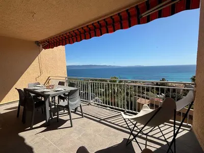 a balcony with a table and chairs and the ocean at Studio K4 santa lina sanguinaires Ajaccio in Ajaccio