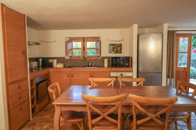 a kitchen with a wooden table and wooden chairs at La bergerie de Sotta in Sotta