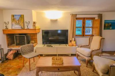a living room with a television and a living room with a table at La bergerie de Sotta in Sotta