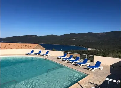 a swimming pool with lounge chairs and a swimming pool at Mini Villa Alba Rossa in Serra-di-Ferro