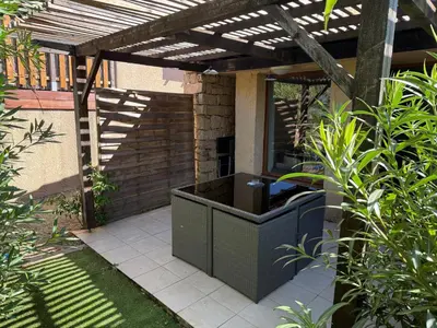 a patio with an outdoor kitchen under a pergola at Mini Villa Alba Rossa in Serra-di-Ferro