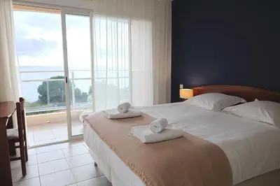 a bedroom with a large bed with towels on it at Les Sanguinaires N31 - T2 Vue Mer, Piscine, Plage in Ajaccio
