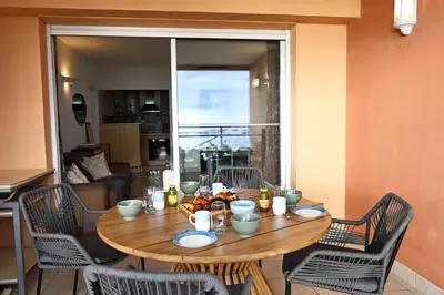 a table with food on it in a room with a large window at Les Sanguinaires N31 - T2 Vue Mer, Piscine, Plage in Ajaccio