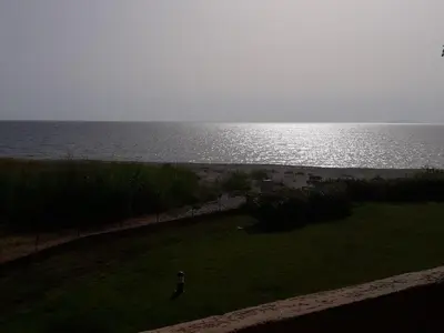 a person standing in a field next to the ocean at Marines de Moriani in Moriani Plage