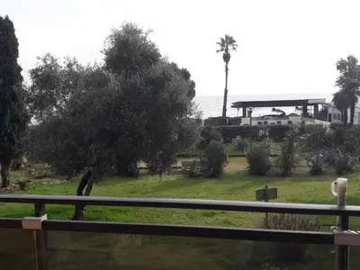 a park with a fence and trees and a building at Marines de Moriani in Moriani Plage