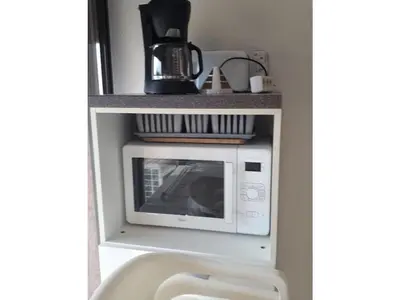 a microwave in a shelf in a kitchen at Marines de Moriani in Moriani Plage