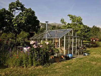 a greenhouse in a garden with flowers and plants at Cabin in Montegrosso with Wi-Fi in Montegrosso