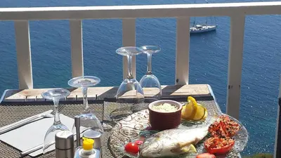 a table with wine glasses and food on a balcony at Bel Mare in Cargèse