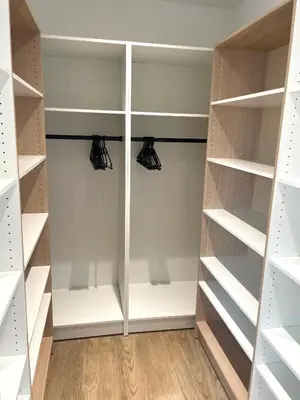 a walk in closet with white shelves at Villa avec piscine privée in Venzolasca