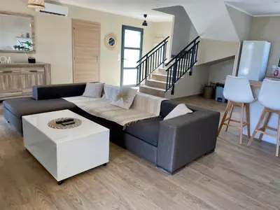a living room with a couch and a table at Villa avec piscine privée in Venzolasca