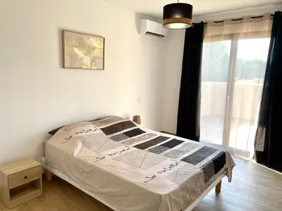 a bedroom with a bed and a large window at Villa avec piscine privée in Venzolasca