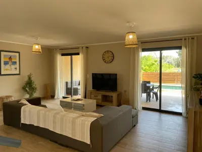 a living room with a large bed and a television at Villa avec piscine privée in Venzolasca