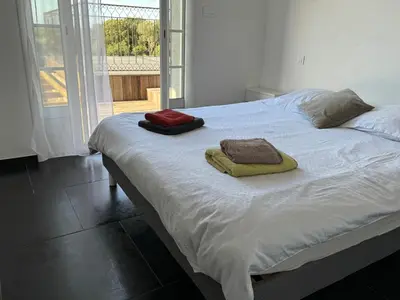 a white bed with two pillows on top of it at Villa Ratino in Bonifacio