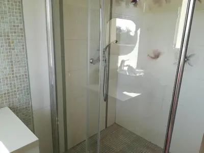 a shower with a glass door in a bathroom at Villa 300m2 piscine chauffée et jacuzzi-spa de nage in Afa