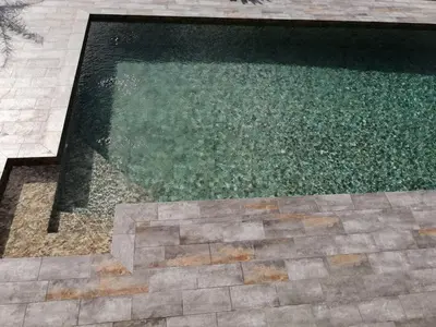a pool of water with some rocks in it at Villa 300m2 piscine chauffée et jacuzzi-spa de nage in Afa