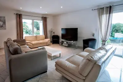 a living room with couches and a flat screen tv at Villa 300m2 piscine chauffée et jacuzzi-spa de nage in Afa