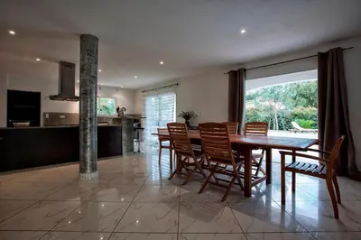 a kitchen and dining room with a table and chairs at Villa 300m2 piscine chauffée et jacuzzi-spa de nage in Afa