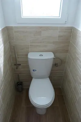 a white toilet in a bathroom with a window at Duo de Mini-villas, gîtes chaleureux & vue mer in Olmeto