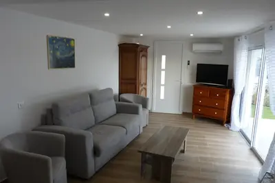 a living room with a couch and a table and a tv at Duo de Mini-villas, gîtes chaleureux & vue mer in Olmeto
