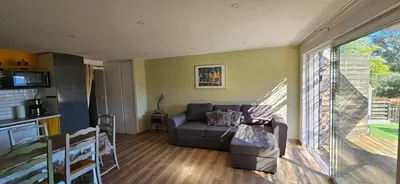 a living room with a couch and a large window at Duo de Mini-villas, gîtes chaleureux & vue mer in Olmeto