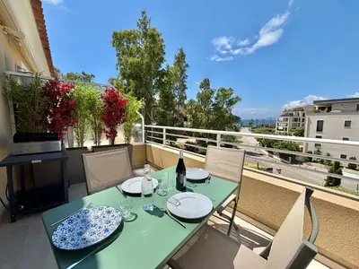 a green table and chairs on a balcony at Appartement Altu Mare 2 pièces avec terrasse AGOSTA PORTICCIO in Albitreccia