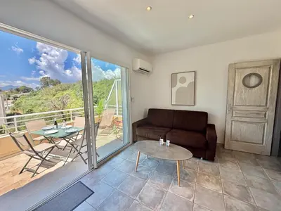 a living room with a couch and a table at Appartement Altu Mare 2 pièces avec terrasse AGOSTA PORTICCIO in Albitreccia