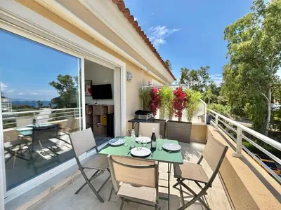 a patio with a table and chairs on a balcony at Appartement Altu Mare 2 pièces avec terrasse AGOSTA PORTICCIO in Albitreccia