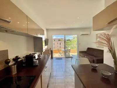 a kitchen and living room with a couch and a table at Appartement Altu Mare 2 pièces avec terrasse AGOSTA PORTICCIO in Albitreccia